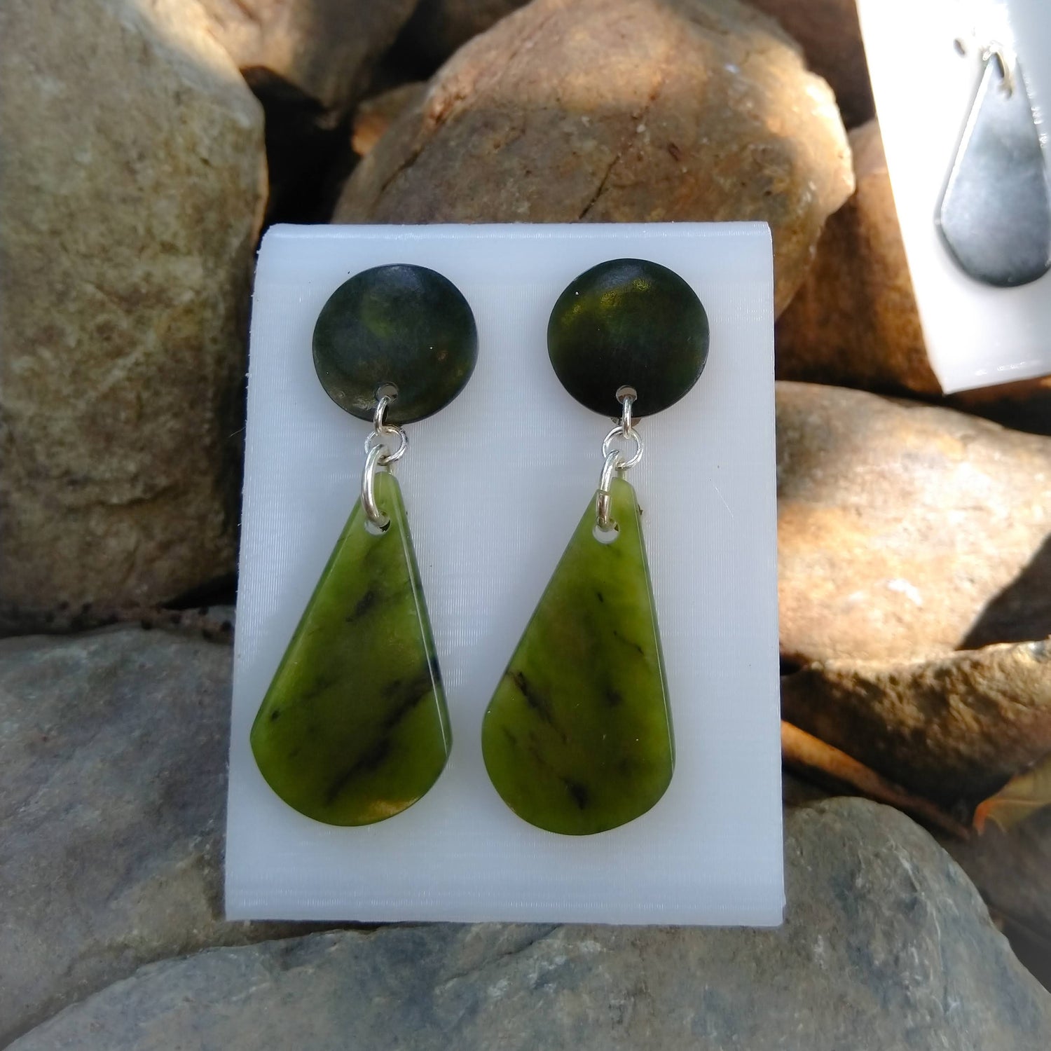 Close-up of a woman wearing jade green earrings, highlighting their elegant design and natural beauty.